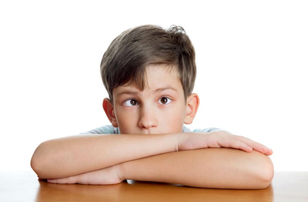 A young child with amblyopia, a lazy eye, in front of a white background