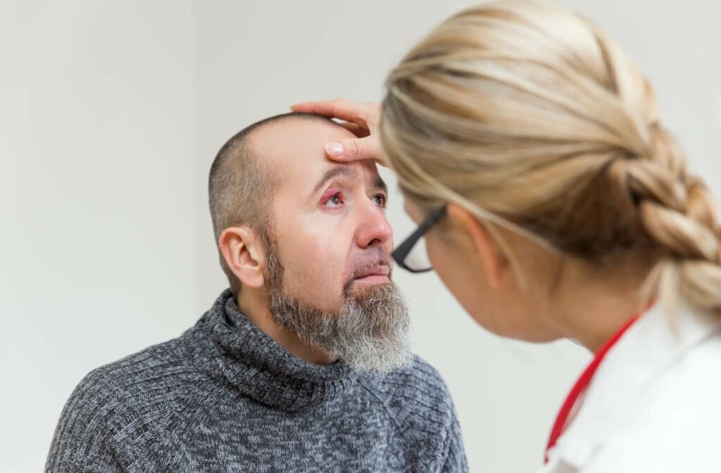 An eye doctor examining a patient with a stye on their left eye.