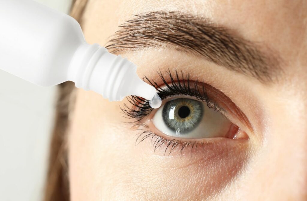 A close-up image of an eye receiving an eye drop from a bottle