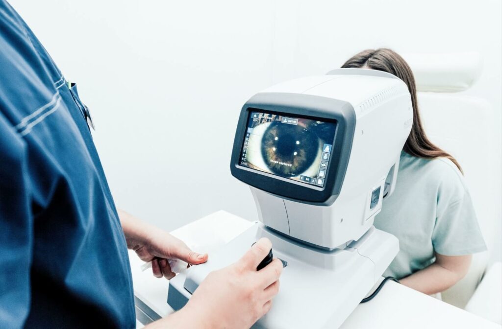 A professional examines a patient's eye using medical equipment that shows a close up of the eye.