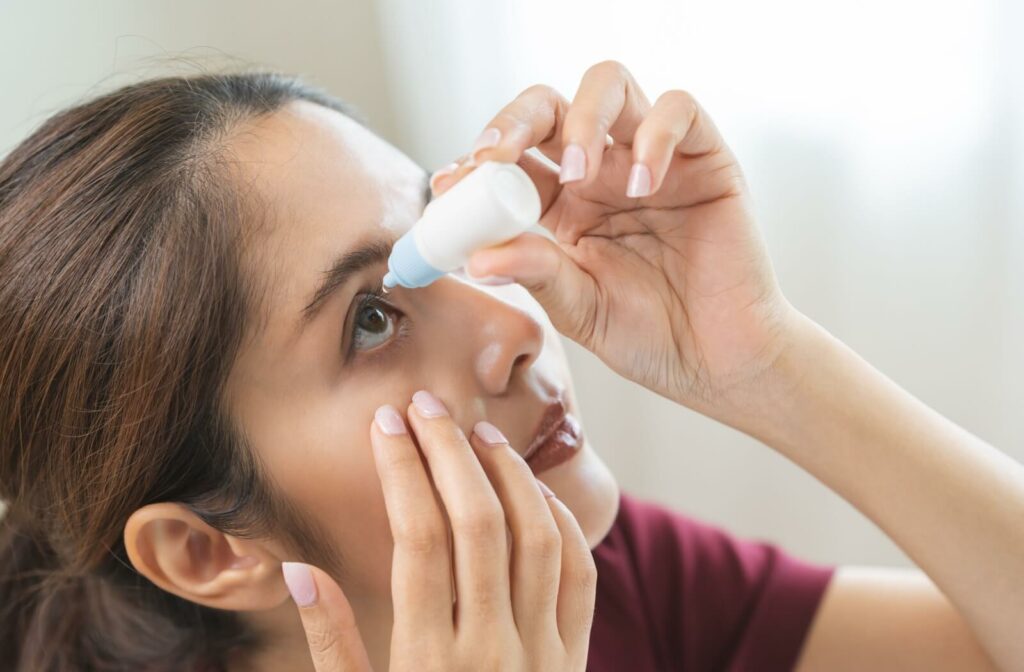 Person applying eye drops as part of dry eye treatment at home.