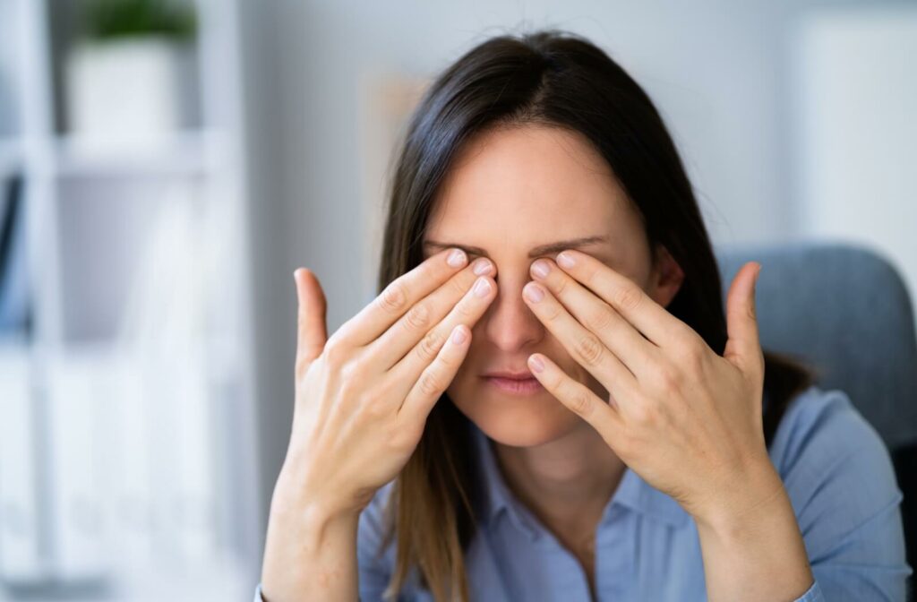 A person rubbing her eyes with both hands, appearing to experience eye discomfort or irritation.